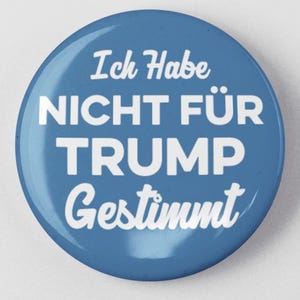 May include: A blue round button with white text that reads "Ich Habe Nicht Für Trump Gestimmt".