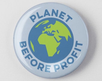 May include: A round, light blue button with the words "PLANET BEFORE PROFIT" in a circular arrangement. The button features a green and blue graphic of the Earth in the center, promoting environmental awareness.