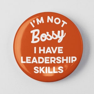 May include: Orange button with white text that reads "I'm not bossy I have leadership skills".