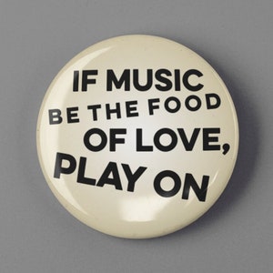 May include: A white button with black text that reads "If music be the food of love, play on."