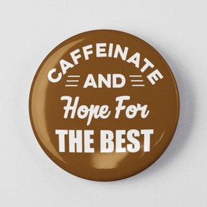 May include: Brown button with white text that reads "Caffeinate and Hope for the Best".