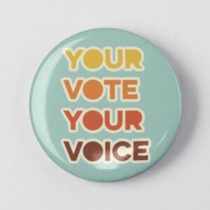 May include: A blue button with the text "YOUR VOTE YOUR VOICE" in a retro font with orange, yellow, and brown accents.