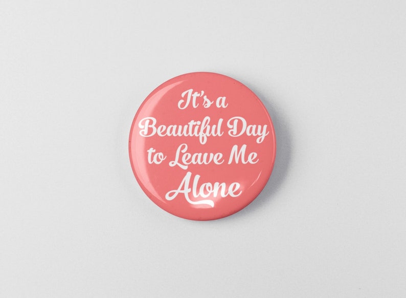 May include: A pink button with white text that reads "It's a Beautiful Day to Leave Me Alone."