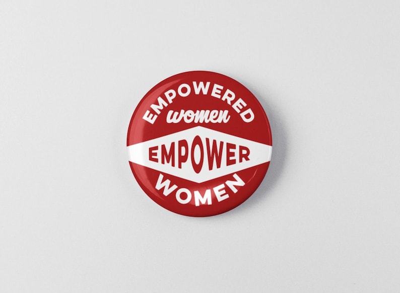 May include: Red round button with the text "EMPOWERED women EMPOWER WOMEN" in white.