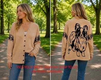 May include: A tan V-neck cardigan with a button-down front and long sleeves featuring a black paw print band. The back displays a large black graphic of a long-haired dog. The text PICK YOUR BREED FROM MY SHOP TO GO ON YOUR CARDIGAN is visible.