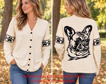 May include: A cream-colored V-neck cardigan with a button-down front and long sleeves featuring black paw print bands. The back displays a large black graphic of a French Bulldog. The text CHOOSE YOUR BREED FROM MY SHOP TO GO ON YOUR CARDIGAN.