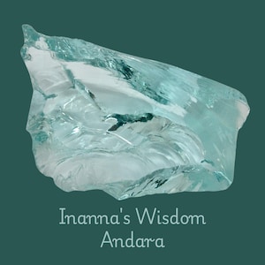 May include: A light blue, translucent crystal with a rough, uneven form. The crystal is displayed against a dark teal backdrop. The image includes the text "Inanna's Wisdom Andara."