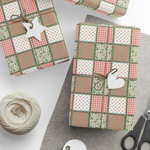 May include: Three wrapped gifts with patchwork patterned paper in red, green, and brown. Each gift is tied with twine and a white paper tag. A ball of twine, scissors, and blank tags are also visible.
