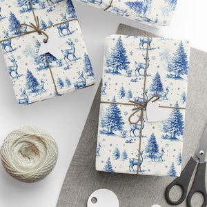 May include: Gift-wrapped presents with blue and white forest and deer pattern. Each package is tied with twine and a blank tag. A ball of twine, scissors, and blank tags are also visible.