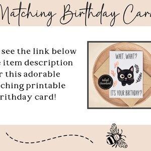 K&ouml;nnte beinhalten: Eine druckbare Geburtstagskarte mit einer Illustration einer schwarzen Katze und dem Text "WAIT. WHAT? ITS YOUR BIRTHDAY?". Die Karte liegt auf einem Holztablett mit einem Umschlag. Der Text "Matching Birthday Card" ist ebenfalls vorhanden.