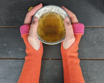 Knitted lambswool reversible wrist warmers in orange and bubblegum pink