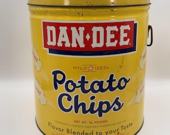 May include: A vintage yellow metal Dan-Dee potato chip tin with a red and white logo, blue text reading Potato Chips, and a net weight of 1 1/4 pounds printed on the front. The cylindrical container features a metal lid and side handle.