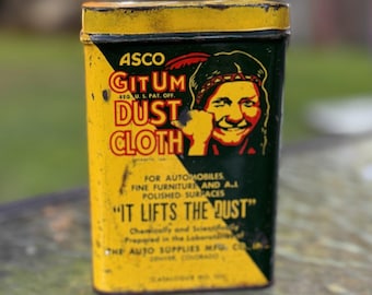May include: A rectangular yellow and dark green metal tin for Asco Git Um Dust Cloth. The front features a graphic of a person, the text "It Lifts The Dust," and details about the Auto Supplies Mfg. Co. in Denver, Colorado, with a yellow lid.