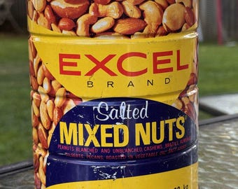May include: A cylindrical metal can of Excel Brand Salted Mixed Nuts with a clear plastic lid. The yellow label features red text reading EXCEL BRAND and blue text reading Salted MIXED NUTS, with a net weight of 36 oz. (2 lbs. 4 oz.) 1.02 kg.
