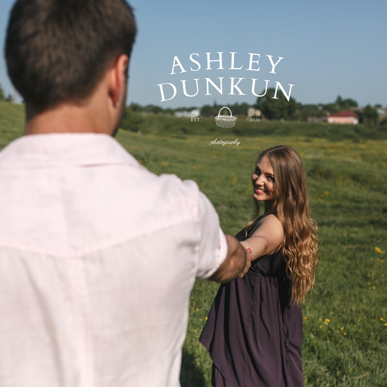May include: A woman in a dark purple dress smiles while holding hands with a person in a white shirt. The image is set in a field with the text "ASHLEY DUNKUN" and "photography" in the background.