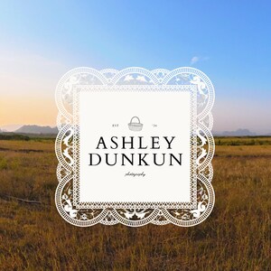 May include: A white, ornate logo with the text "ASHLEY DUNKUN photography" against a backdrop of a field and sky. The logo has a decorative border and a small basket illustration.