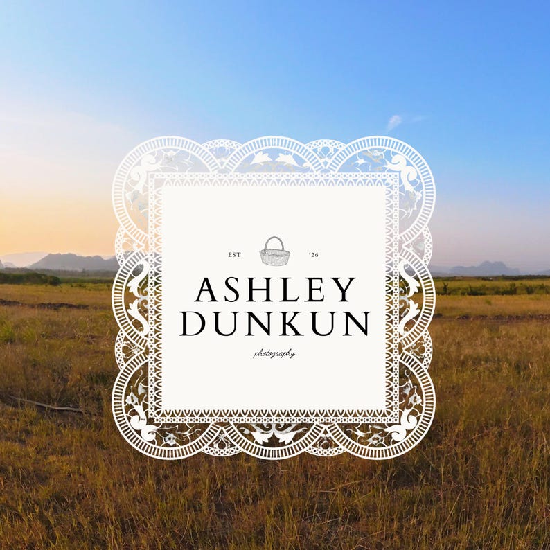 May include: A white, ornate logo with the text "ASHLEY DUNKUN photography" against a backdrop of a field and sky. The logo has a decorative border and a small basket illustration.