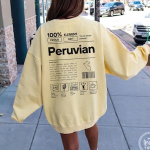 Peut inclure: Un sweat-shirt jaune clair avec l'inscription "100% Element Peruvian" en noir. Le dos du sweat-shirt présente un graphique avec une carte du Pérou et d'autres icônes. Le mot "Butter" est dans le coin supérieur gauche.