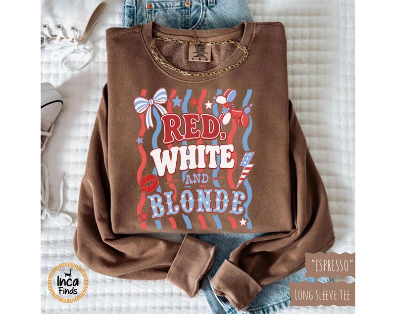 May include: A brown long-sleeve sweatshirt with the text "Red, White, and Blonde" in red, white, and blue. The design includes a bow, stars, a balloon dog, a kiss, and a lightning bolt. The sweatshirt is labeled "Espresso".
