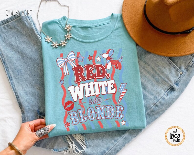 May include: A turquoise t-shirt featuring the text "RED, WHITE AND BLONDE" in red and white, with patriotic designs. A brown hat and blue jeans are also visible in the image.