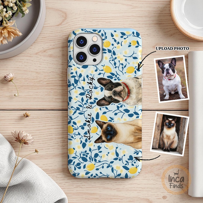 May include: A light blue smartphone case featuring a pattern of yellow lemons and dark blue leaves. The case displays a custom illustration of a French Bulldog and a Siamese cat, with the text "Smokie & Rocky" printed in a black script font.