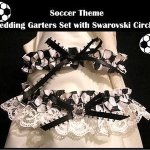 Könnte beinhalten: Ein schwarz-weißes Fußball-Hochzeits-Gartensets mit einer schwarzen Schleife und einem klaren Strass-Verzierungen. Das Strumpfband ist aus weißer Spitze und schwarzem Satin.