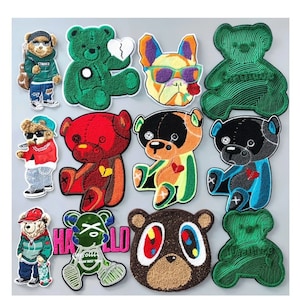May include: A set of 10 embroidered iron-on patches featuring various cartoon bears, a dog, and a bear with a large eye design. The patches are colourful and feature different styles and designs.