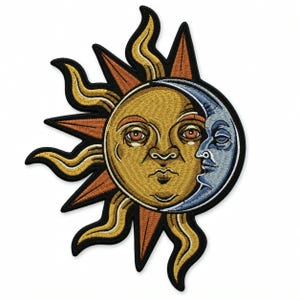 Puede incluir: Un parche bordado que muestra un sol dorado con rostro humano y rayos ondulados, parcialmente eclipsado por una luna creciente azul con rostro humano. El diseño está delineado con hilo negro grueso, creando un motivo celestial.
