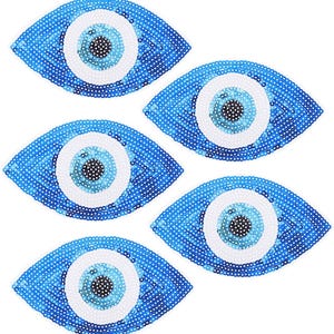 Könnte beinhalten: Fünf blaue und weiße böse Augen-Anhänger mit Pailletten. Die Anhänger sind in Form eines Auges mit einer weißen Iris und einer blauen Pupille.