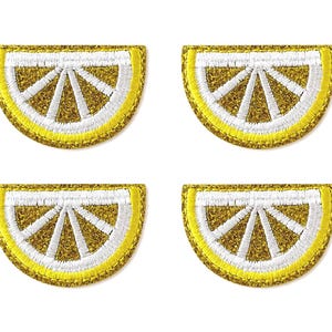 Può includere: Quattro toppe ricamate semicircolari a forma di fettine di limone. Ogni toppa presenta un bordo giallo brillante, una scorza interna bianca e segmenti riempiti con una texture glitterata dorata, disposti in una griglia due per due.