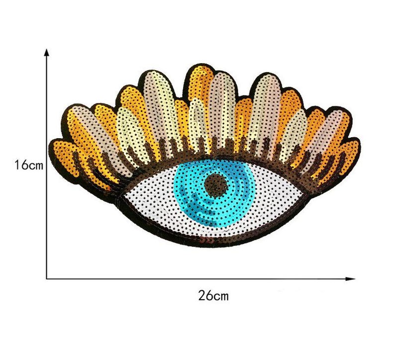 May include: A decorative eye-shaped patch, 16cm high and 26cm wide, with a blue iris and a black outline. The eyelashes are a mix of gold, white, and brown sequins. The eye is embellished with sequins.
