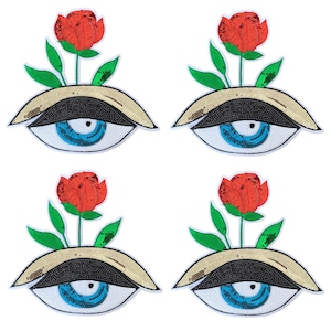 May include: Four decorative eye patches with a red rose and green leaves sprouting from the top. The eyes have blue irises, black pupils, and gold and black sequined eyelids. The patches are on a white background.