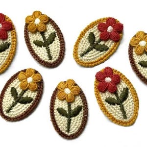 Könnte beinhalten: Ein Set aus sechs ovalen Stickaufnähern, die jeweils eine einzelne Blume mit grünem Stiel und Blättern auf cremefarbenem Grund zeigen. Die Blüten sind entweder rot oder gelb und jeder Aufnäher hat einen dicken, strukturierten Rand.