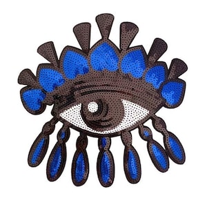 以下が含まれることがあります： キラキラ光る青いラインストーンで飾られた、大きく茶色と青の目。目は青いラインストーンの冠で囲まれています。