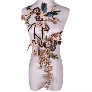 May include: A brown, green, and beige embroidered applique featuring a bird and floral designs. The applique is perfect for adding a touch of elegance to clothing, bags, or home decor projects.