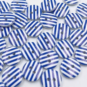 Könnte beinhalten: Eine Sammlung von blauen und weißen gestreiften Holz-Knöpfen. Die Knöpfe haben zwei Löcher und sind perfekt für Nähprojekte.
