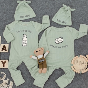 May include: Two green baby onesies with matching hats. One onesie has a milk bottle graphic and the text "Can't have one... without the other". The other onesie has a cookie graphic and the text "...without the other".