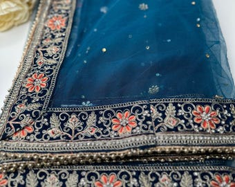May include: A teal blue net dupatta with a black and gold embroidered border. The border features intricate floral designs with red accents.