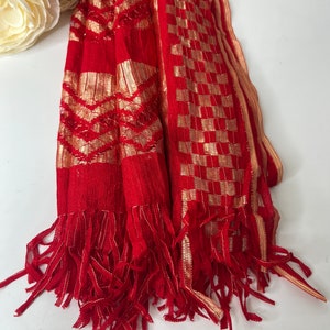 Puede incluir: Chaleco rojo con patrones geom&eacute;tricos dorados y ribete de flecos.