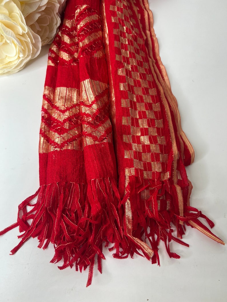 Puede incluir: Chaleco rojo con patrones geom&eacute;tricos dorados y ribete de flecos.