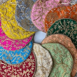 May include: A collection of drawstring pouches in various colors including yellow, gray, pink, orange, green, blue, red, and cream. Each pouch features intricate gold-colored floral embroidery and is finished with a pearl-beaded drawstring cord.