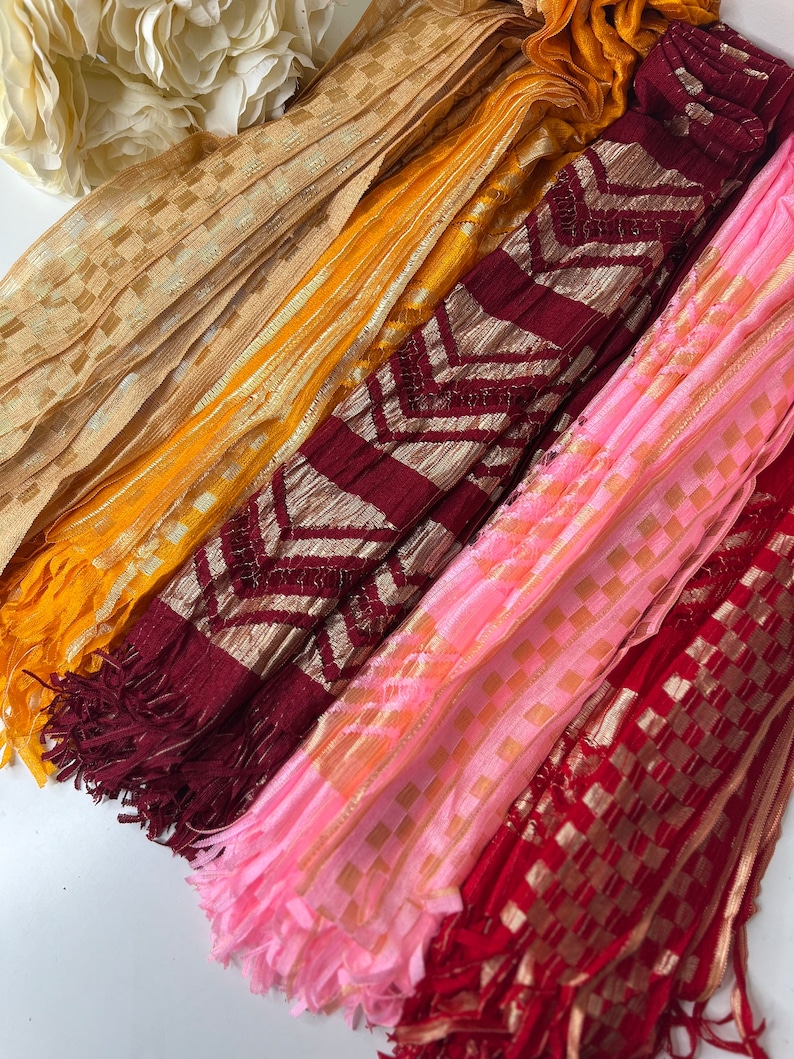 Puede incluir: Cuatro tipos diferentes de ribetes de tela con acentos dorados. Los ribetes son en tonos de rosa, rojo, amarillo y marr&oacute;n. Cada ribete tiene una franja en el extremo.