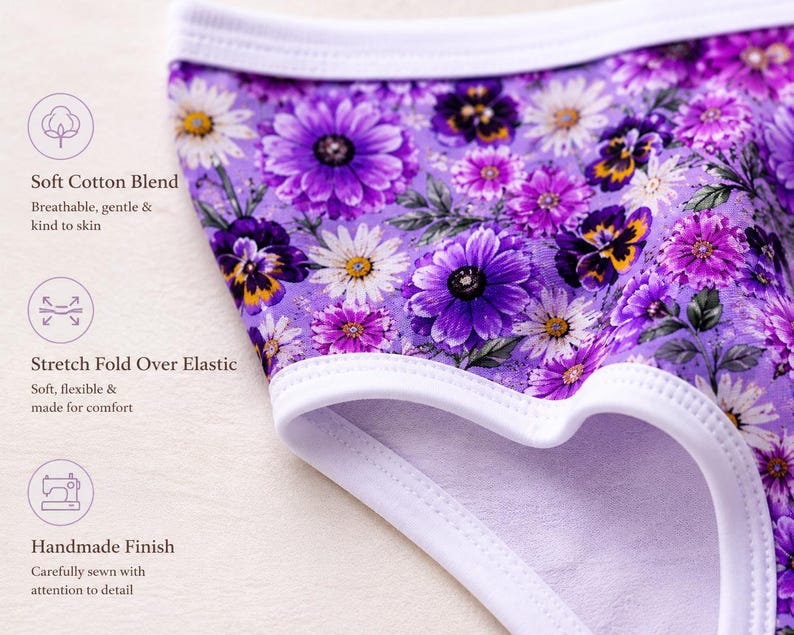 May include: Close-up of purple floral underwear with a white trim. The fabric features a pattern of purple, white, and yellow flowers. The text on the image says "Soft Cotton Blend", "Stretch Fold Over Elastic", and "Handmade Finish".