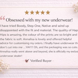 May include: A customer review card with the text "Obsessed with my new underwear!" and a five-star rating. The review praises the quality, fit, and fabric of Happy Hips underwear. Delicate white flowers adorn the corners.