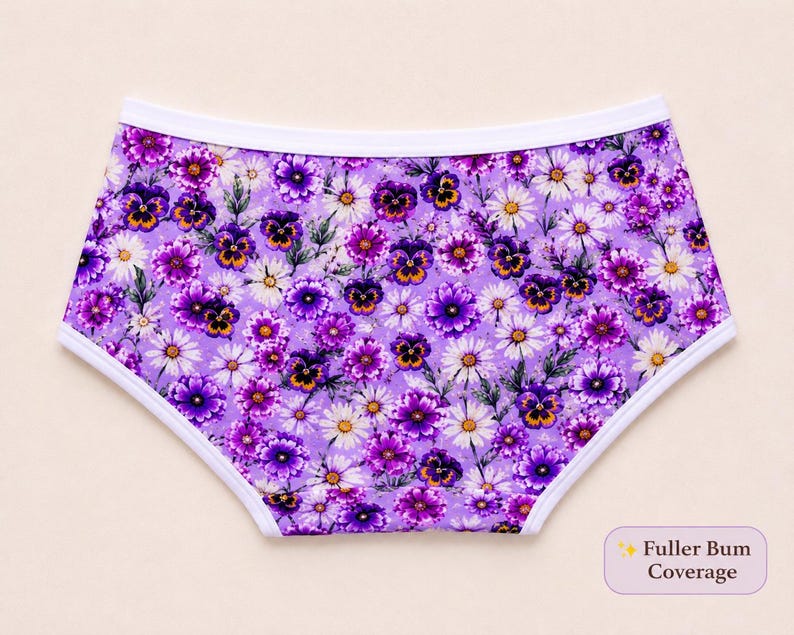 May include: Purple floral underwear with a white trim. The underwear features a pattern of purple pansies and white daisies on a lavender background. The text "Fuller Bum Coverage" is in the lower right corner.
