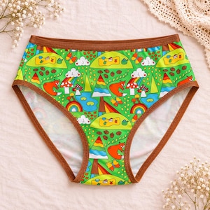 May include: High-waisted underwear featuring a vibrant green background with a repeating pattern of orange foxes, colourful rainbows, pine trees, mushrooms, butterflies, acorns, and picnic scenes with cakes and teapots, finished with brown trim.