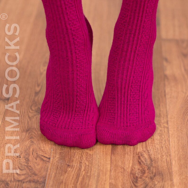 May include: A pair of pink ribbed socks with a textured knit pattern.