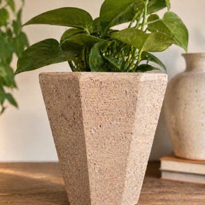 Maceta vintage de terracota con textura facetada y orificio de drenaje, estilo Japandi Decor.