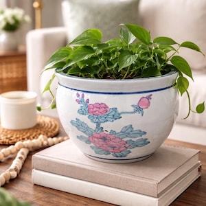 Może przedstawiać: Zestaw trzech ceramicznych kubków z nakrapianym, matowym wykończeniem. Kubki są w odcieniach kremu, jasnoszarym i ciemnoszarym. Każdy kubek ma prosty, minimalistyczny design.