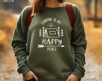 May include: A green sweatshirt with the text "Camping is my happy place" and a graphic of a tent, trees, and an arrow.